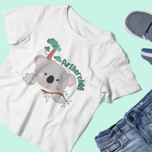 A kids' t-shirt featuring an illustrated koala bear, paired with a set of blue jeans.