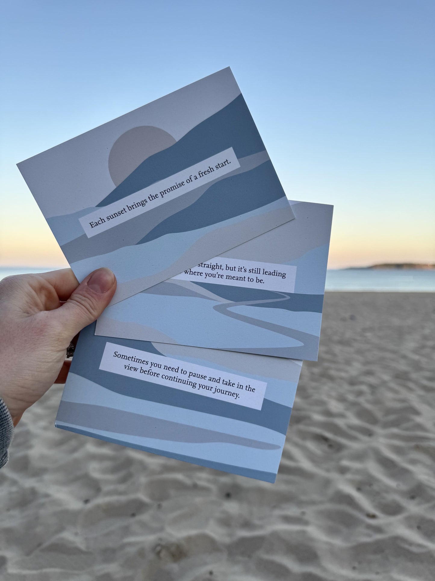 Thinking of you cards by local Welsh maker, surrounded by sand and gentle waves in the background.