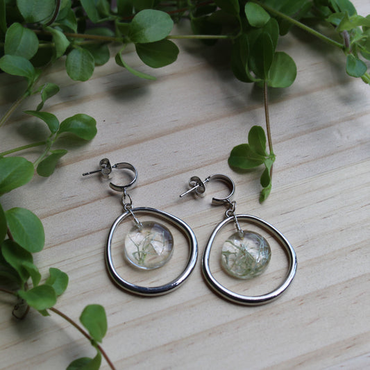 Silver circle drop earrings on wooden table with foliage. Perfect gift for jewellery lovers, sustainable style seekers, or anyone who loves bold, handmade accessories