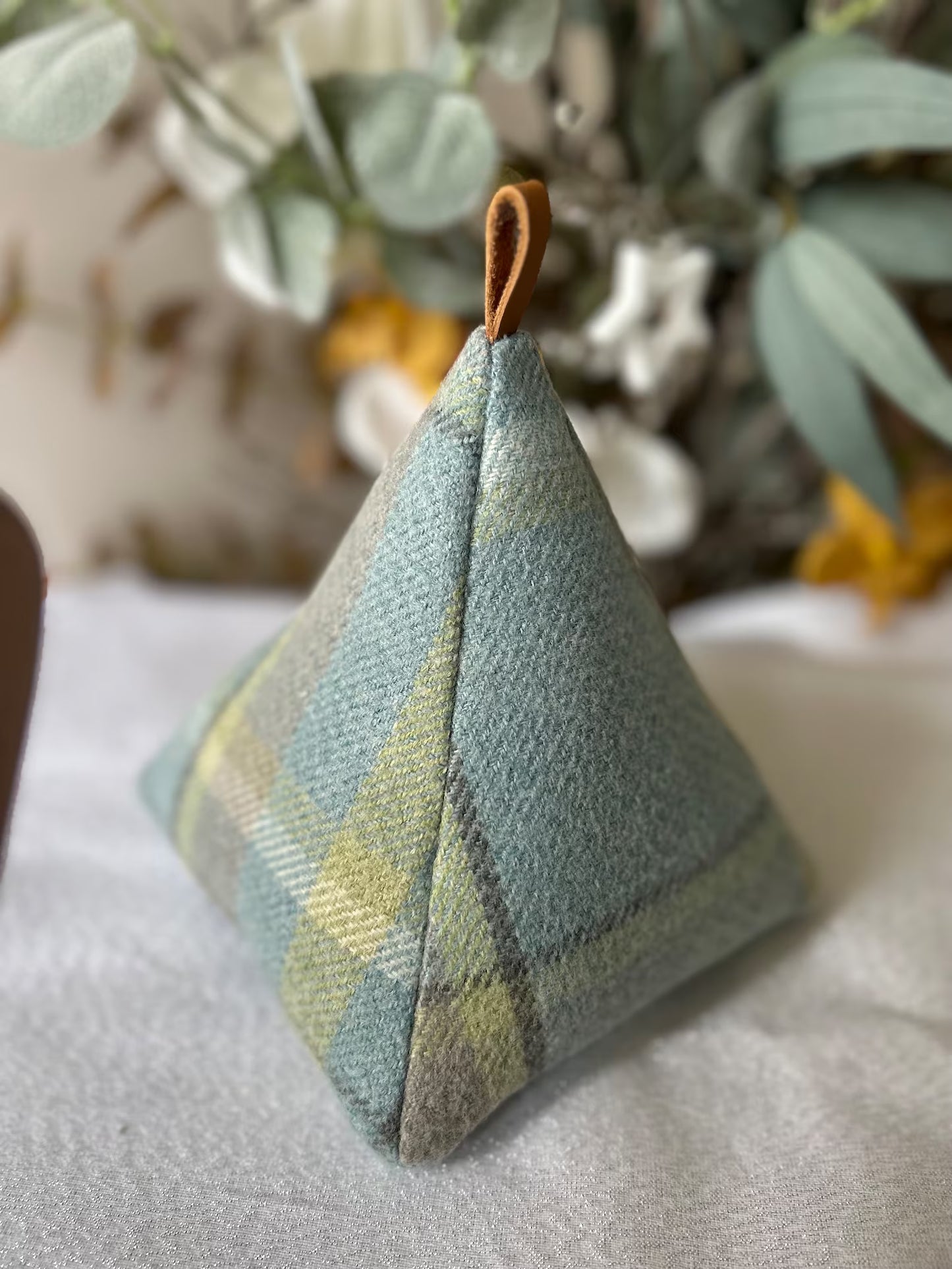 Duck egg blue handmade Welsh wool pyramid doorstop with looped leather handle, soft-touch fabric, unique Welsh home accessory.