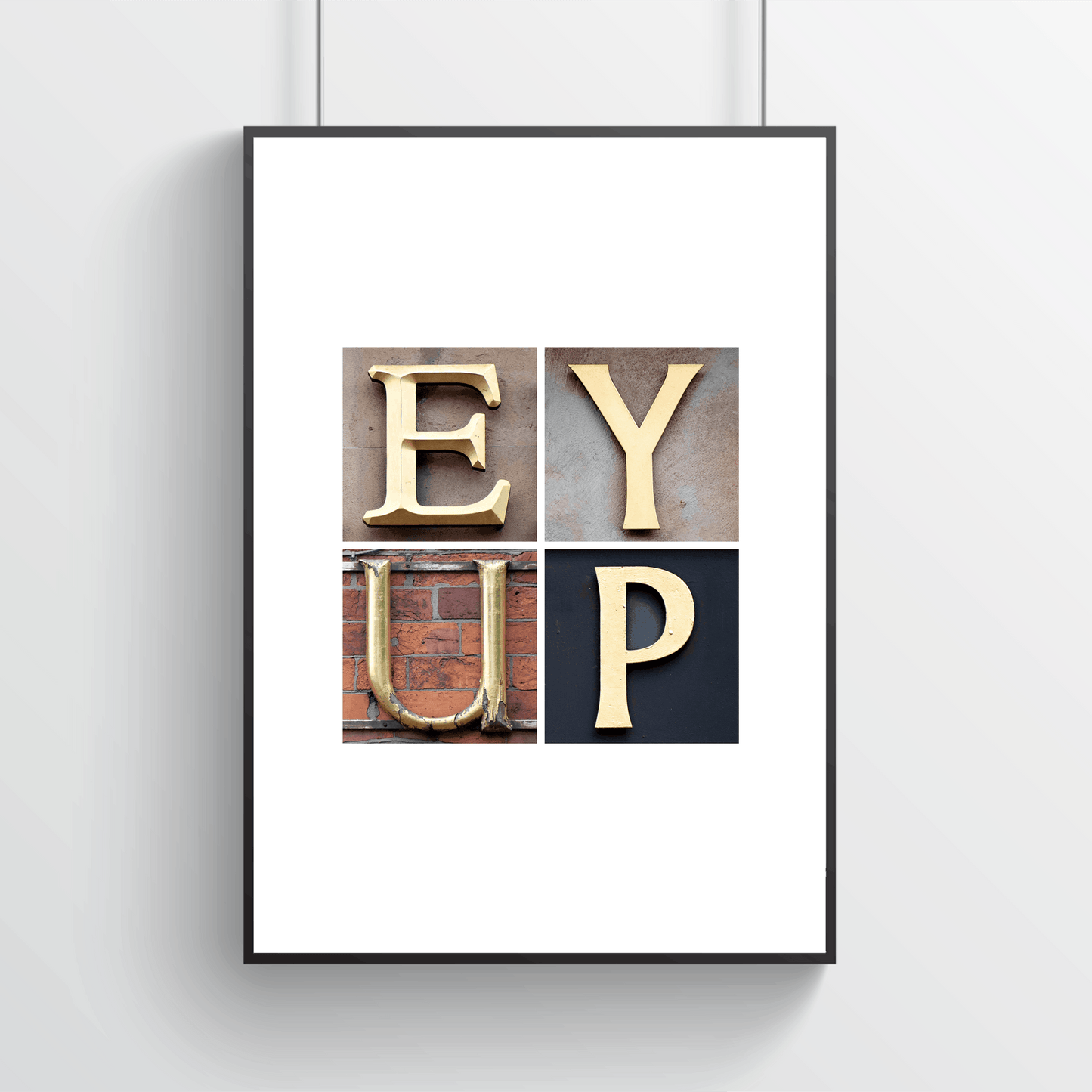 Framed artwork with 'EY UP' text on a white wall. Yorkshire inspired typography artwork for home decor.
