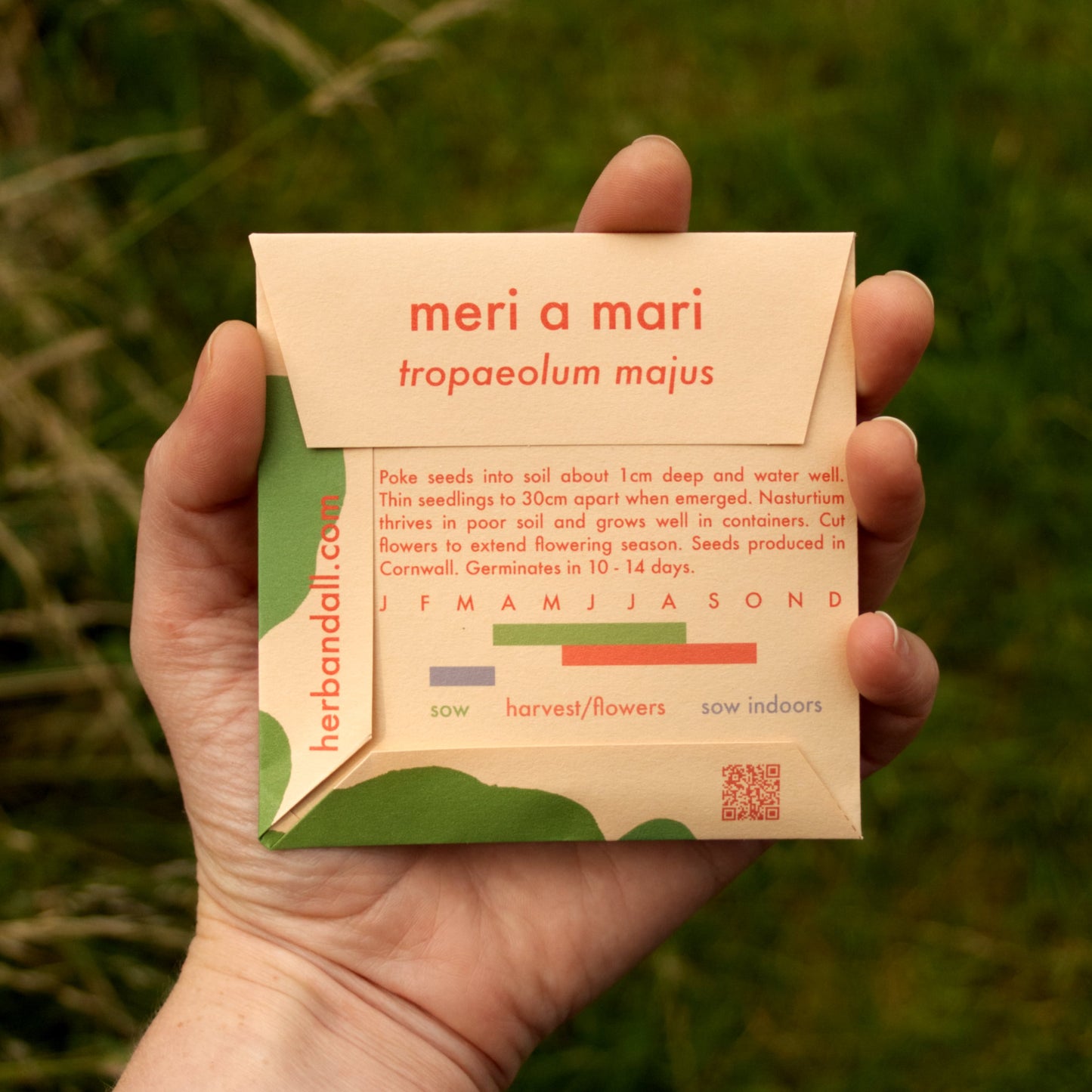 Hand holding a seed packet with 'meri a mari' branding against a natural background