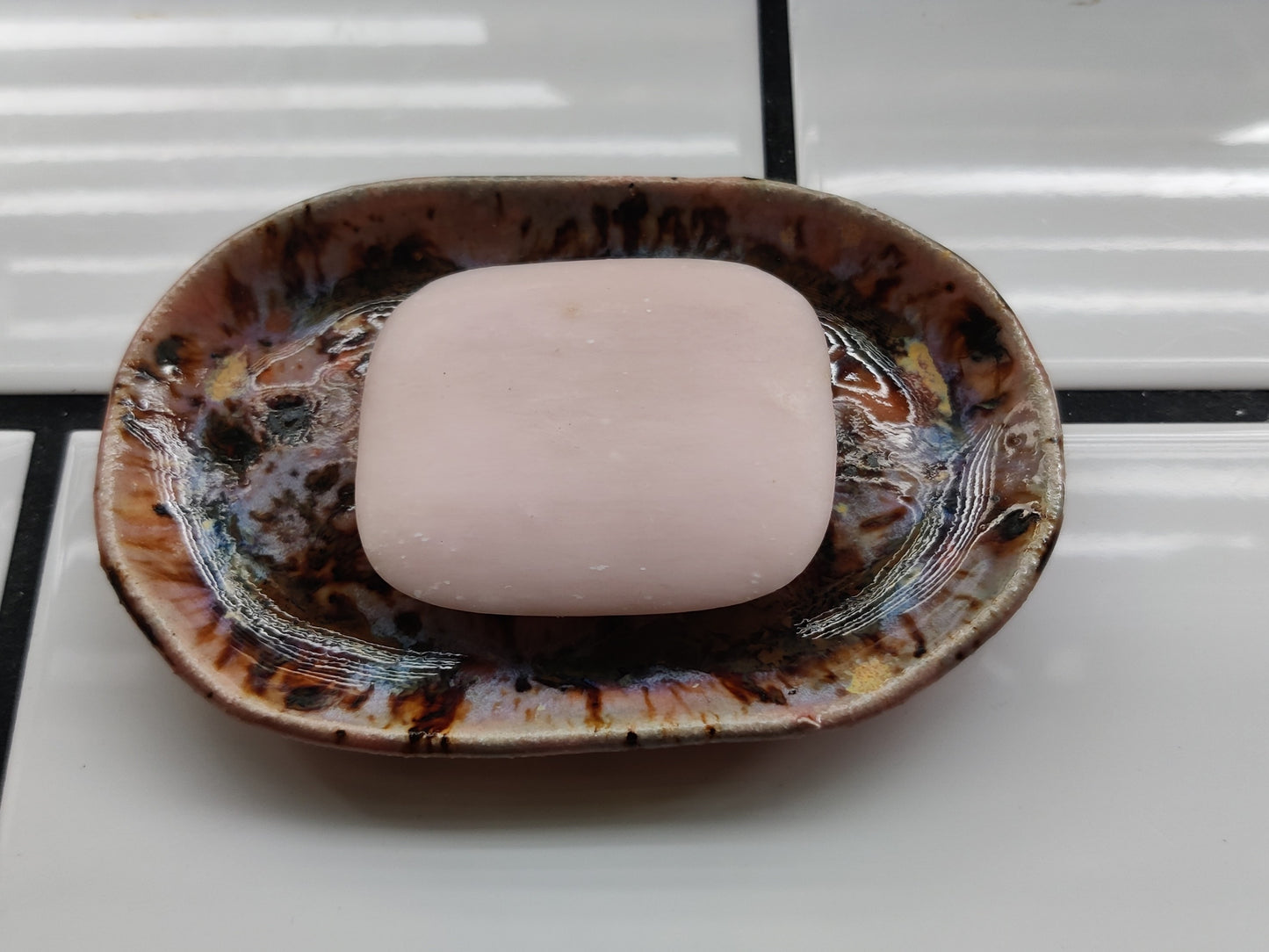 Handmade peach coloured ceramic soap dish with soap on top, made by local maker in Wales.