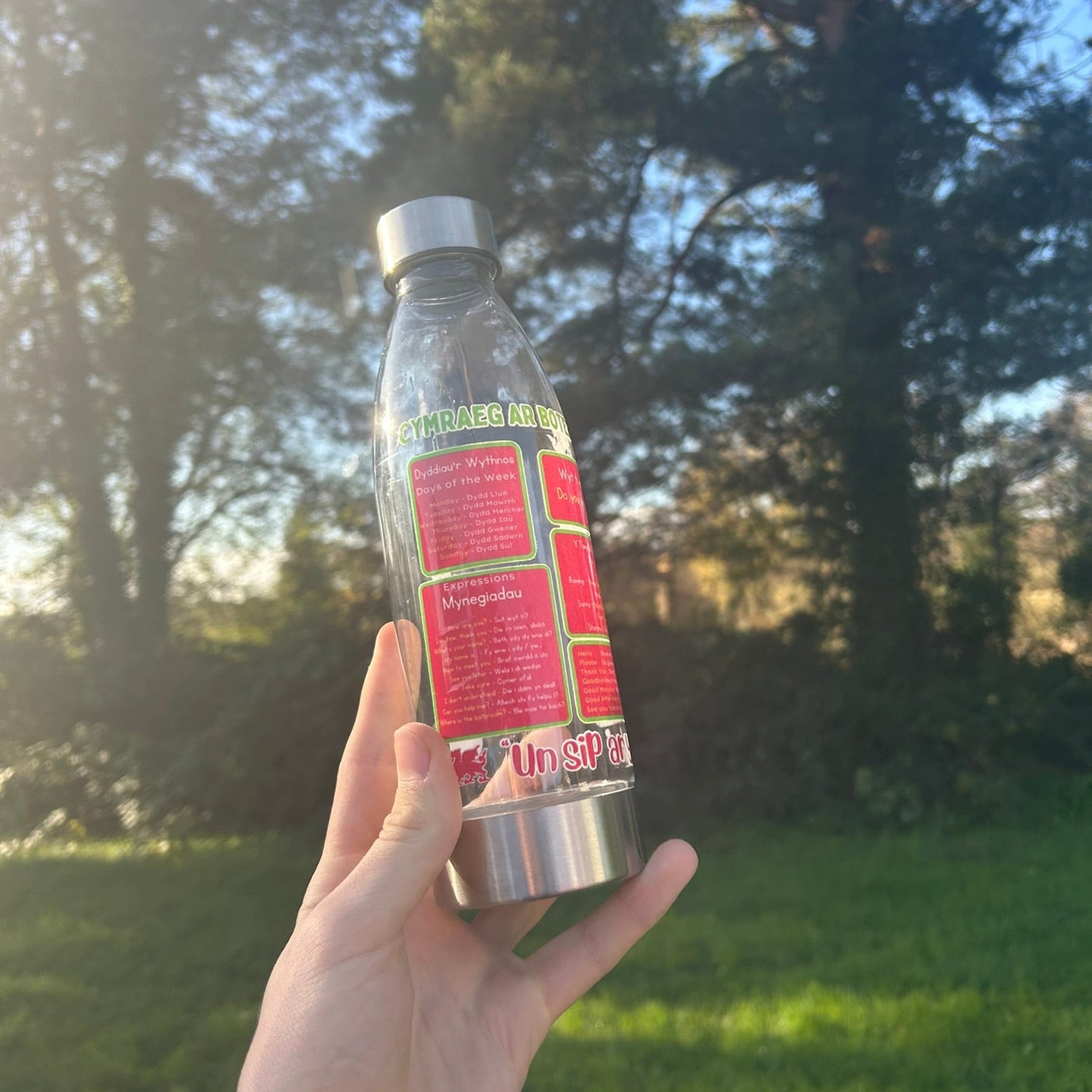 Clear Welsh water bottle showing days of the week and common expressions, perfect for Welsh learners or as a gift from Wales