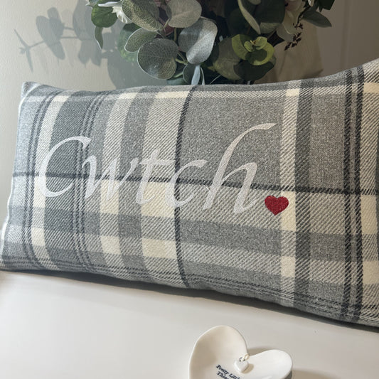 Stylish and understated, this grey Welsh Cwtch cushion is handmade in Wales from unique textiles. Perfect for adding a cosy touch to Welsh home décor.