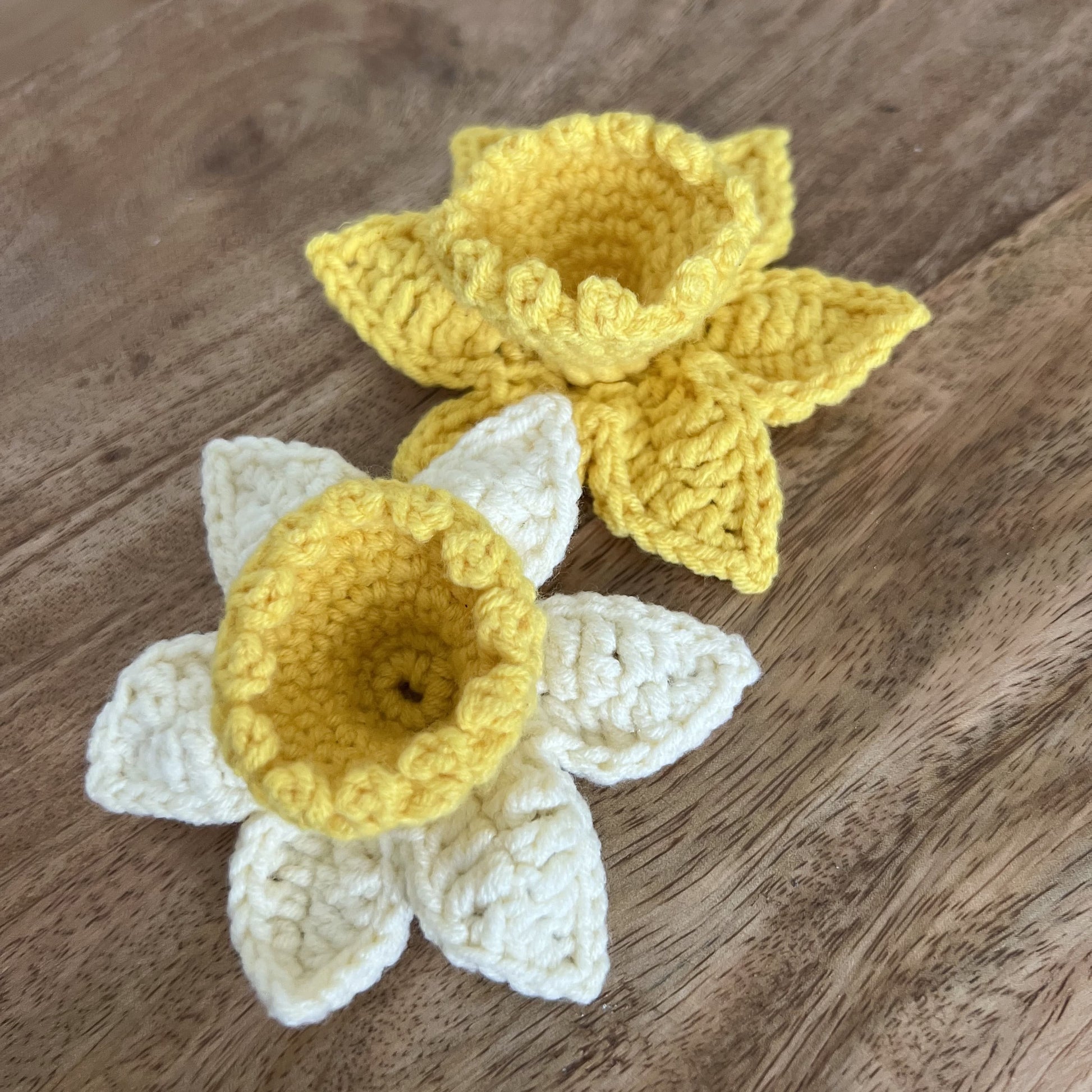 Close-up of yellow crocheted Welsh daffodil pin, handcrafted accessory for celebrating Welsh heritage.