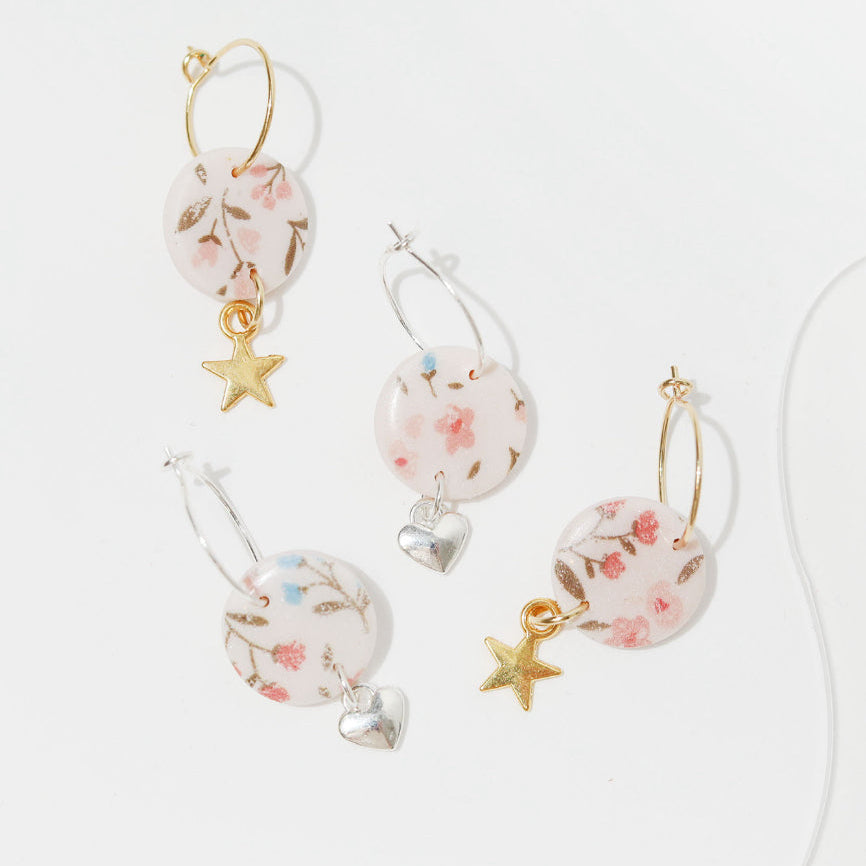 Three pairs of metal hoop earrings featuring floral and star designs in various colours and styles. Whether you're shopping for a thoughtful gift for her, a unique birthday surprise, or a treat just for you – these handcrafted earrings make a beautiful addition to any jewellery collection.
