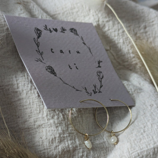 Handmade pearl hoops clipped onto a card backing featuring the Welsh words 'Caru Ti'