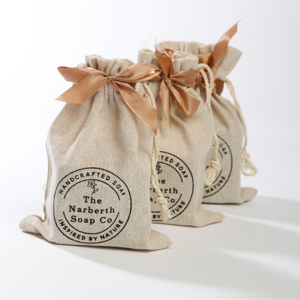 Close up of three artisan soaps gift bags, made in Wales by The Narberth Soap Co, beautifully wrapped in a cotton gift bag. 