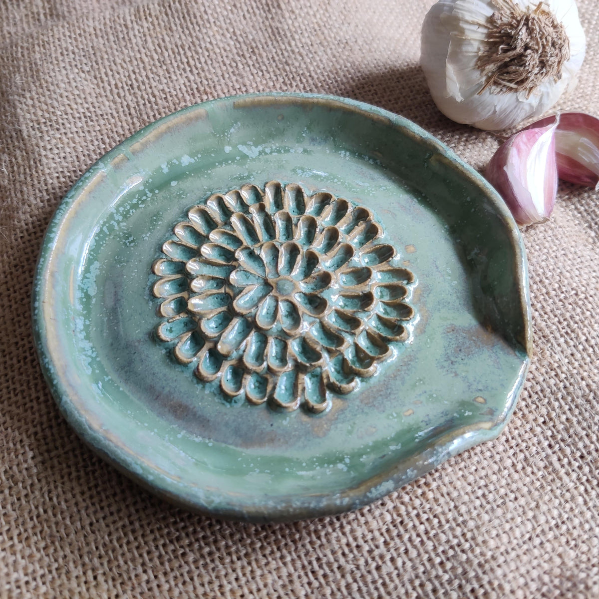 Ivy handmade ceramic garlic grater on a featuring a delicate flower design. Perfect unique gift for food lovers or to add to your kitchen accessories.