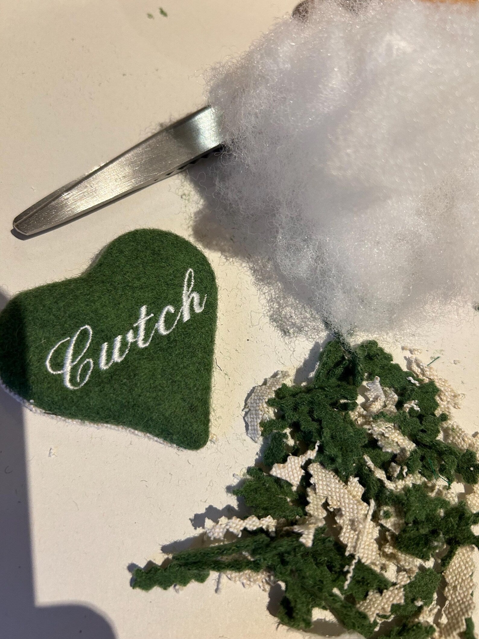 Green heart-shaped handmade keyring with 'Cwtch' text on a textured surface. unique Welsh textile gift accessory for birthdays, Christmas, weddings