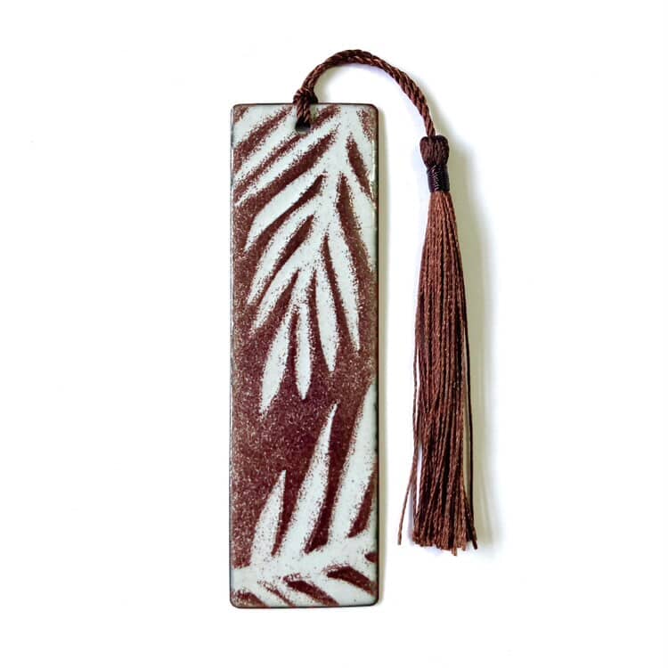 Brown enamelled copper bookmark with leaf pattern and tassel on a white background. Handmade gifts from wales.