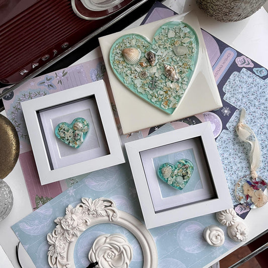 Heart-shaped ocean inspired decorative items on a table with various frames and embellishments.