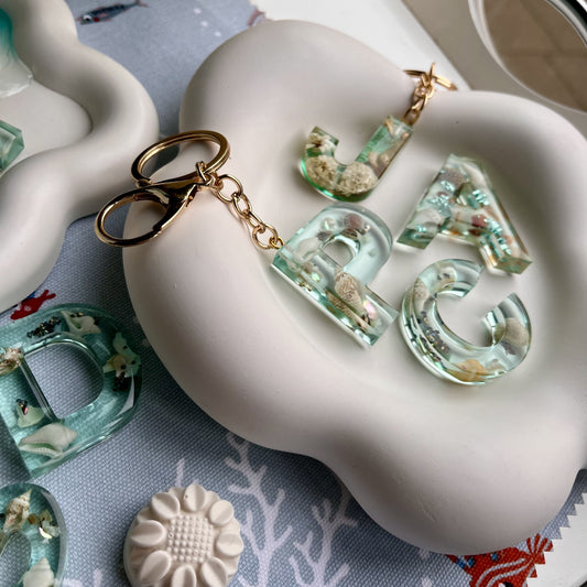 Handmade resin letter keyring with coastal design.
