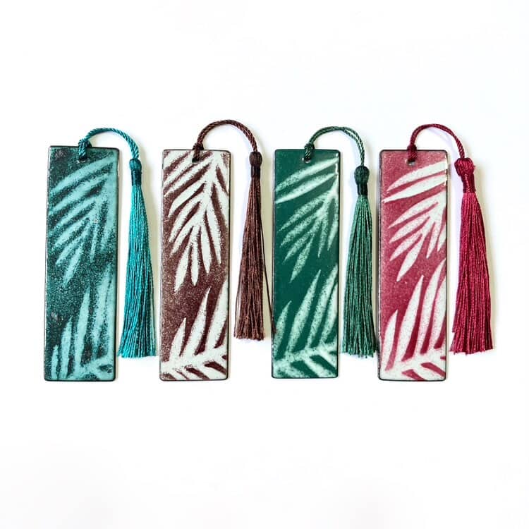 Four decorative bookmarks with leaf patterns and tassels on a white background. Handmade in Wales