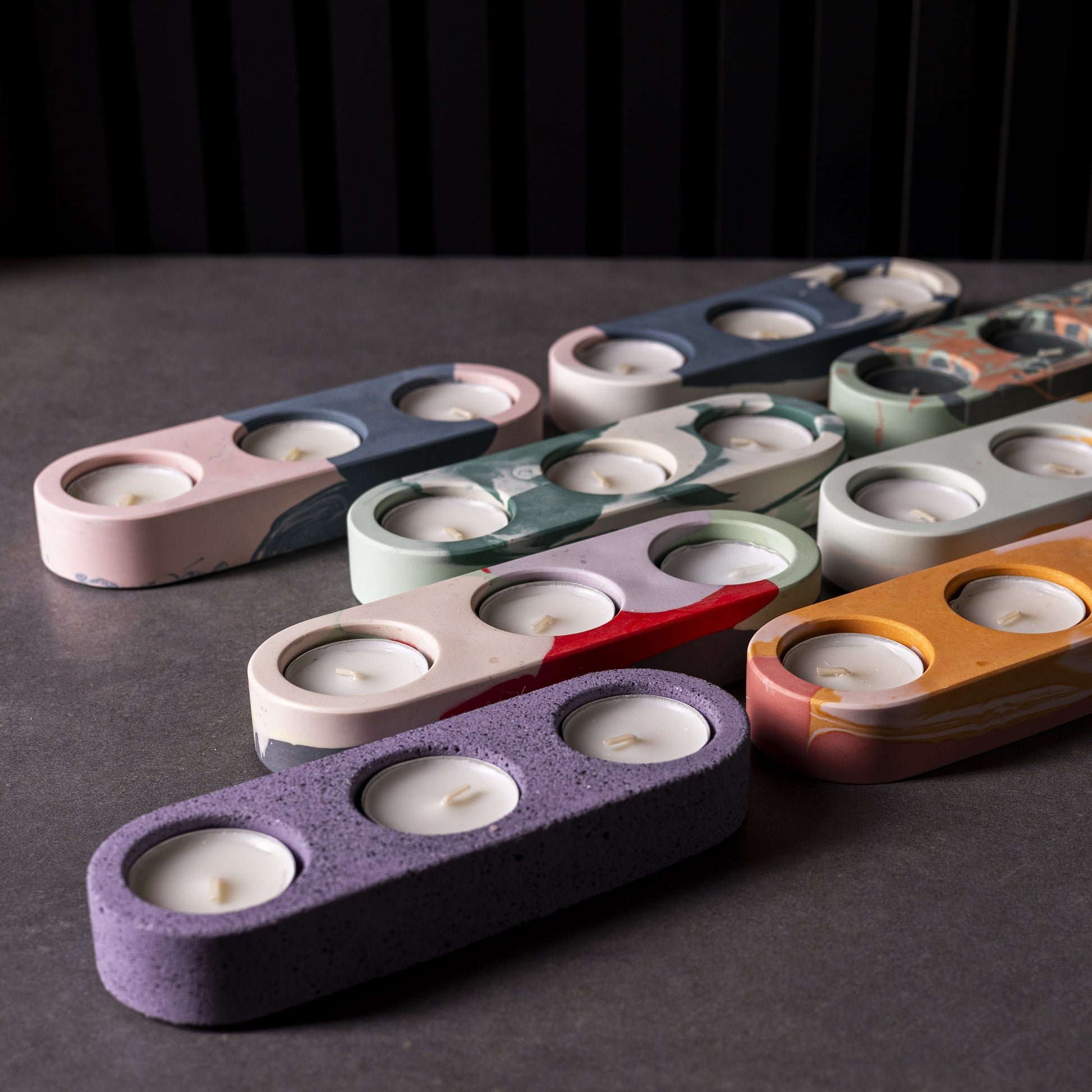 Colorful ceramic tea light holders on a dark surface. Perfect gift for cosy nights in.