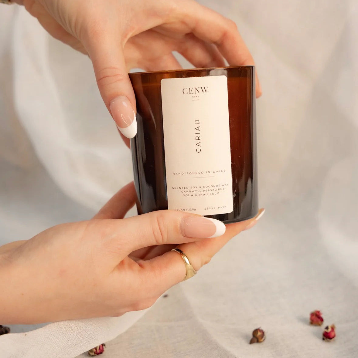 Person holding a Vegan candle with peony and red apple fragrance.