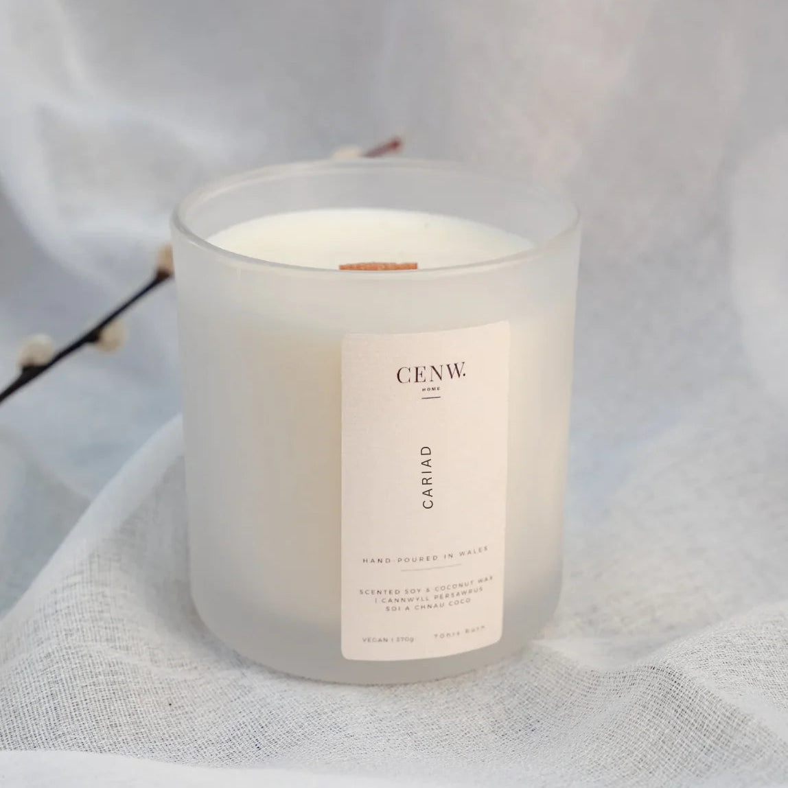 Cariad peony and suede soy candle hand-poured in Wales. White frosted glass on white background.
