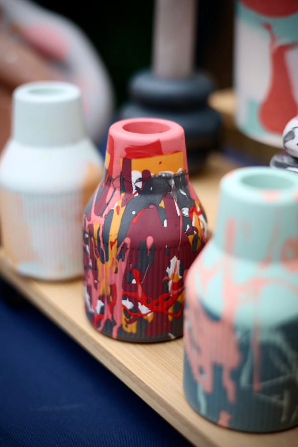 A table showcasing one small ribbed jesomite vase in black and red splattered olours. Perfect as a gift or to add to your home.