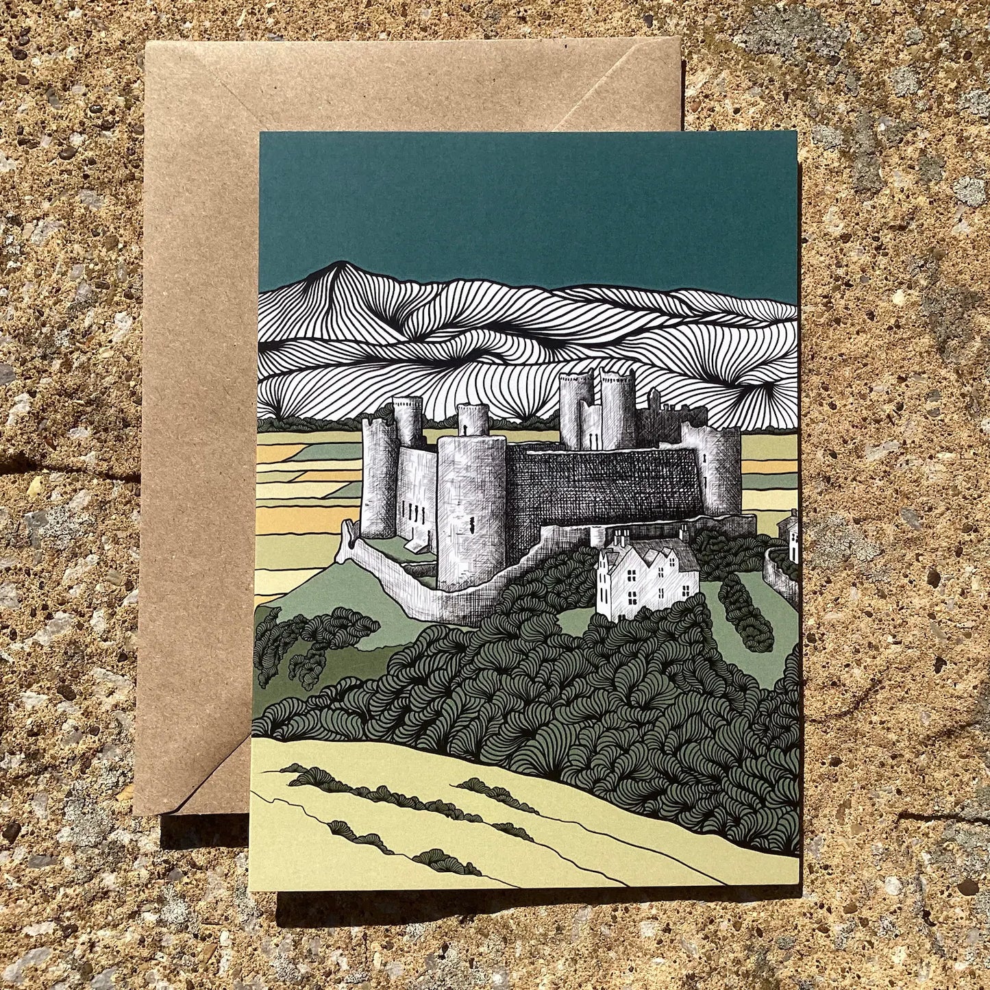 Greeting card with Harlech castle illustration on a textured surface. Welsh heritage greeting card supporting independent Welsh makers.