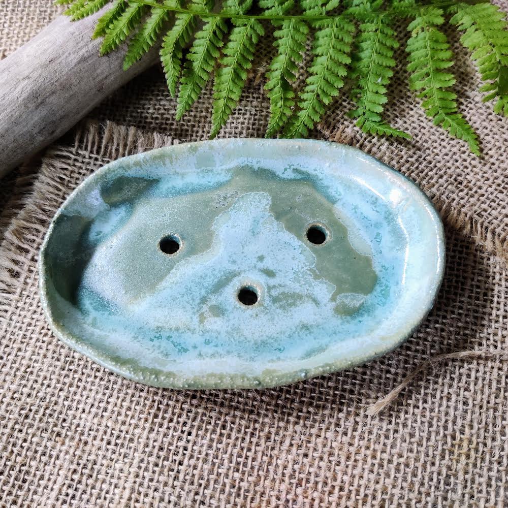 Ivy/green/blue handmade ceramic soap dish on textured background. Made in Wales.