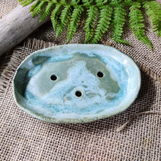 Ivy/green/blue handmade ceramic soap dish on textured background. Made in Wales.