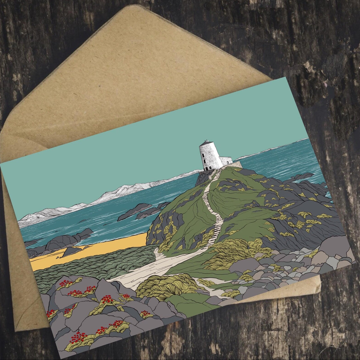 Welsh landscape art Greeting card with a lighthouse design on a wooden surface. Supporting Welsh independent artists.
