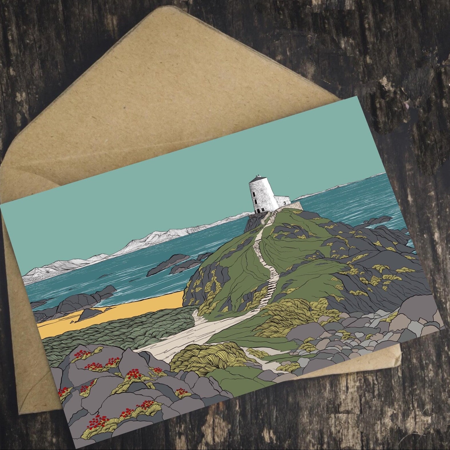 Welsh landscape art Greeting card with a lighthouse design on a wooden surface. Supporting Welsh independent artists.