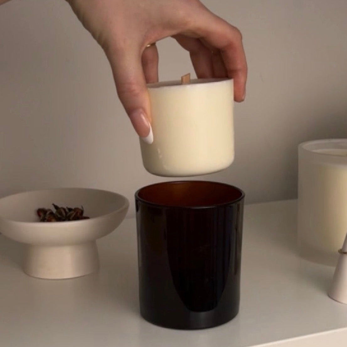 Hand holding a refillable soy candle in amber jar hand-poured in Wales.