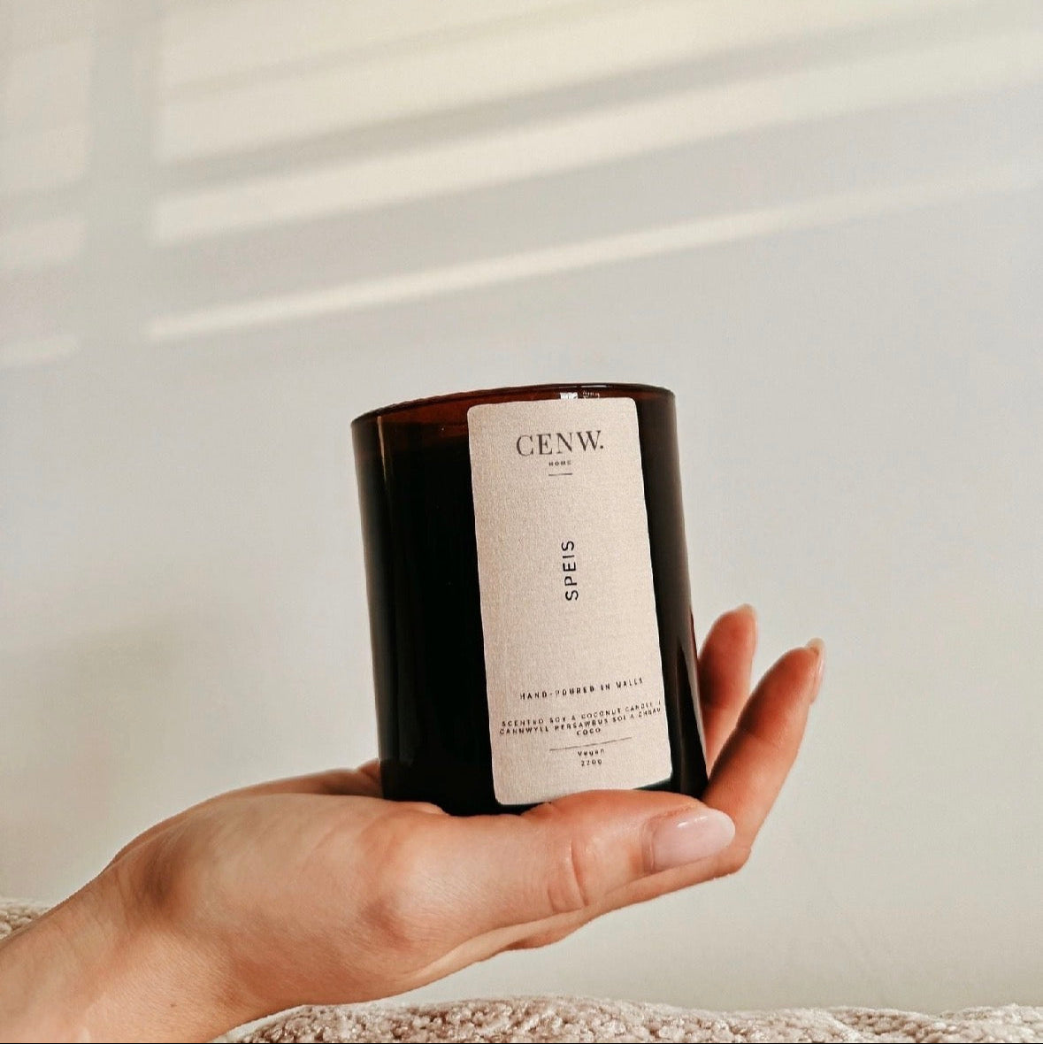 Hand holding handmade Welsh candle with amber and musk fragrance