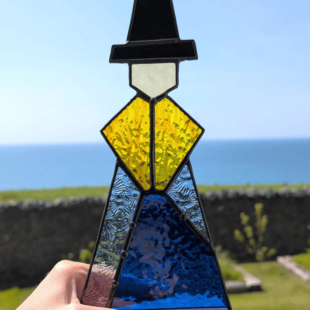 abstract stained glass figure in Welsh hat and skirt, medium size.